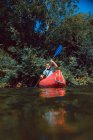 Sportive female canoeist sitting in red canoe and paddling on Sella river decline in Spain — Stock Photo