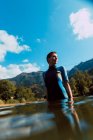 Angolo basso di donna sportiva in piedi nel fiume Sella con gli occhi chiusi contro il cielo blu in Spagna — Foto stock