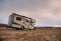 Contemporary travel camper parked on deserted valley by hills in USA — Stock Photo