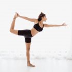 Jovem realizando alongamento postura de ioga no estúdio — Fotografia de Stock