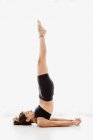 Mulher esportiva realizando ombro ioga pose sobre fundo branco — Fotografia de Stock