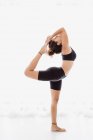 Mulher esportiva realizando alongamento ioga pose sobre fundo branco — Fotografia de Stock