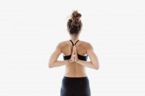Vista trasera de la mujer en forma realizando pose de yoga en estudio - foto de stock