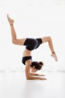 Sportive woman performing yoga pose in studio — Stock Photo