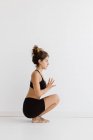 Спортивная женщина, исполняющая позу сидящей йоги в студии — стоковое фото
