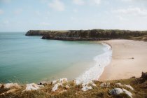 Idyllic view of green water deserted seashore and bare rocks in Barafundle Bay on sunny day — Stock Photo