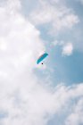 Von unten fliegen Menschen mit bunten Gleitschirmen bei bewölktem Himmel in der Nähe von Durdle Door am Tag — Stockfoto