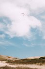 From below people flying with colorful paragliders in cloudy sky near Durdle Door on daytime — Stock Photo