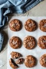 Dall'alto composizione di deliziosi biscotti brownie al cioccolato su pergamena bianca e asciugamano blu — Foto stock