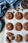 De dessus composition de délicieux biscuits au chocolat brownie sur parchemin blanc et serviette bleue — Photo de stock