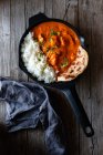 Крупним планом сковорідка, повна смачної масляної курки та рису — стокове фото