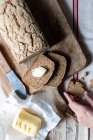 Dall'alto pane di pane ryecorn saporito messo su tovagliolo di stoffa vicino a cucchiaio di grano su sfondo di legno — Foto stock
