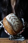Unrecognizable person showing fresh bread — Stock Photo