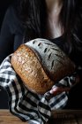 Pessoa irreconhecível mostrando pão fresco — Fotografia de Stock