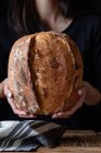 Unerkennbare Person zeigt frisches Brot — Stockfoto