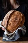 Неузнаваемый человек показывает свежий хлеб — стоковое фото