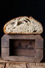 Pane fresco dimezzato con semi contro parete di legno — Foto stock