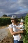 Adorable mother and child on hand enjoying and laughing in field — Stock Photo