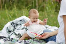 Freudig charmantes Baby auf Decke sitzend — Stockfoto
