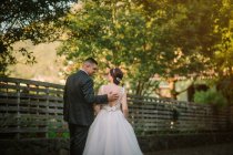Lächelnder Bräutigam und Braut umarmen sich im Park — Stockfoto