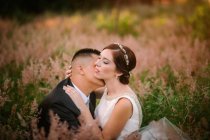 Sorridente sposo e sposa abbracciare e baciare nel parco — Foto stock