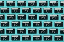 Modello senza cuciture composto da fotocamere aeree vintage disposte su sfondo blu — Foto stock