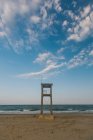 Будівництво спостережень на піщаному пляжі з колісними слідами на хвилястому морі в похмурий день — стокове фото