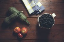Reife Brombeeren garniert mit Gemüse in Schüssel auf Holzgrund — Stockfoto