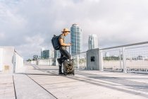 Man in hat and backpack searching for direction on phone — Stock Photo