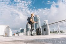 Jeune homme debout avec sa valise et profitant de la vue avant le départ — Photo de stock