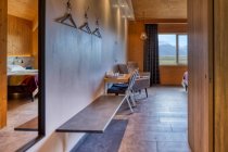 Quarto de hotel limpo e acolhedor com mobiliário confortável e grande janela com vista incrível prado verde tranquilo e montanhas nebulosas borradas — Fotografia de Stock