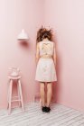Conceptual view from behind of a teenage girl with tangled hairs on pink background — Stock Photo