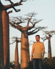 Mann steht bei Sonnenuntergang in der Nähe von Baobab — Stockfoto