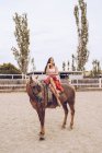 Elegante jinete sentado a caballo arnés caminando a lo largo del paddock - foto de stock