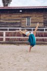 Гнучка жінка в барвистій спідниці танцює на сільському майданчику — стокове фото