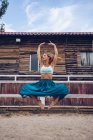 Flessibile donna in gonna colorata che balla al paddock rurale — Foto stock