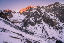 Tranquilles pentes rocheuses de la chaîne de montagnes avec des pics enneigés en plein jour — Photo de stock