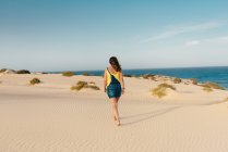 Mujer activa caminando en arena seca del desierto descalza - foto de stock