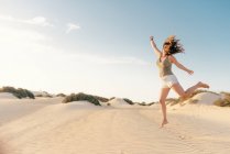 Mujer activa corriendo en desierto seco descalza - foto de stock
