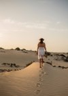 Active woman walking in dry desert barefoot — Stock Photo