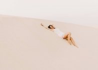 Женщина лежит на песке в пустыне — стоковое фото
