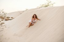 Mulher sentada na areia no deserto — Fotografia de Stock