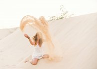 Relaxed funny woman throwing up sand in shore in Fuerteventura, Las Palmas, Spain — Stock Photo