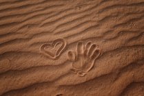 From above hand print in sand and heart signs in Fuerteventura, Las Palmas, Spain — Stock Photo