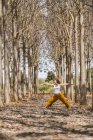 Доросла майбутня мати практикує воїнську позу йоги в парку під час сонячної погоди — стокове фото