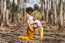 Madre incinta e figlioletta che si abbracciano nel parco autunnale — Foto stock