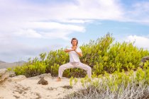 Erwachsene Frau meditiert in der Nähe von Busch — Stockfoto