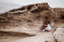 Barefoot woman meditating in rock cavity — Stock Photo