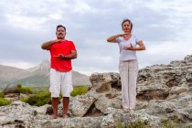 Paar meditiert auf Felsen — Stockfoto