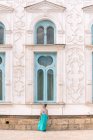 Senhora de vestido descendo degraus do lado de fora edifício ornamental gasto no dia ensolarado em Bukhara, Uzbequistão — Fotografia de Stock
